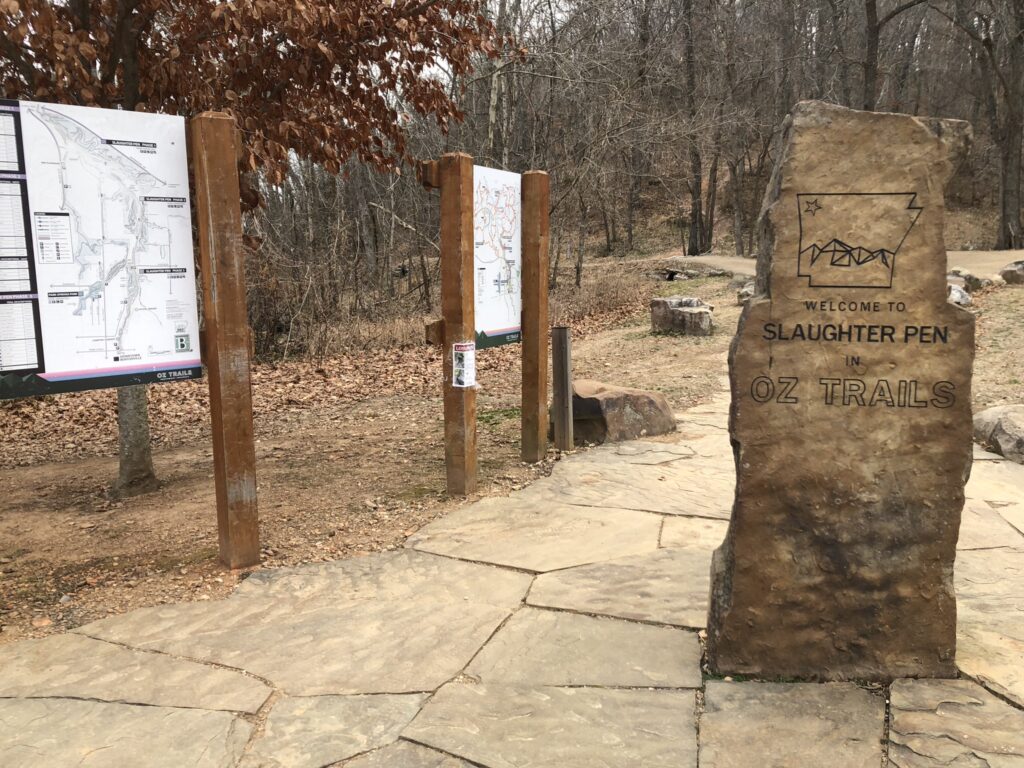 Trailhead kiosk with map boards and the Welcome to Slaughter Pen stone